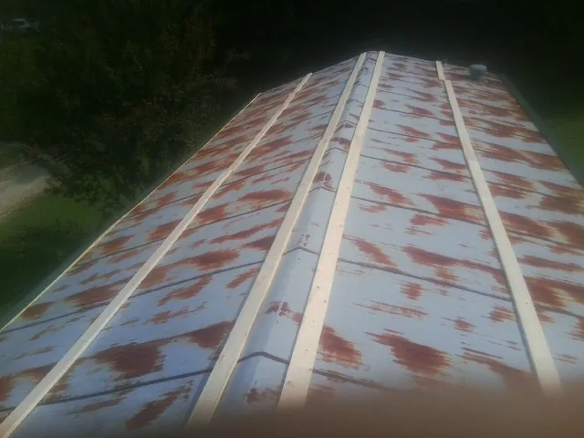 Rusted metal roof panels with new wood purlins before replacement — Storm Damage Roof Repair in Saugus by Roofing Brothers